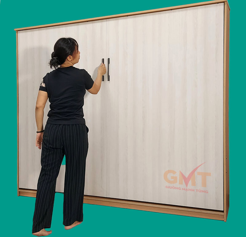Giường gấp thông minh Mạnh Tùng MT-142 khi gấp gọn ngang tường màu vàng nhạt.